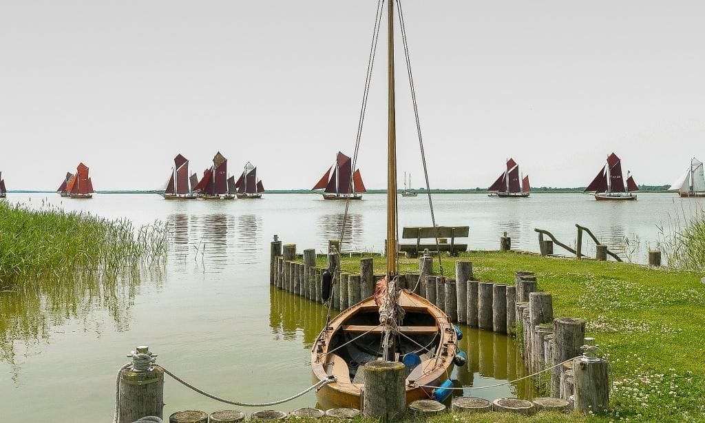 Strand mit Boot und Segelbooten