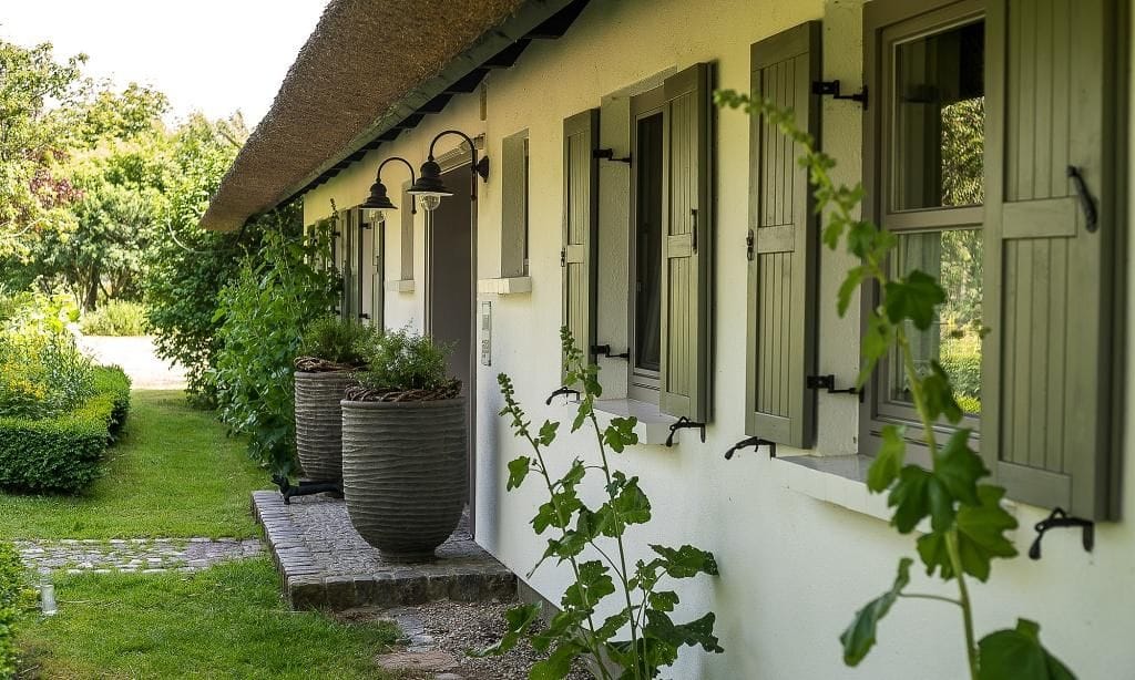 Außenansicht eines Hauses mit Strohdach und Pflanzen