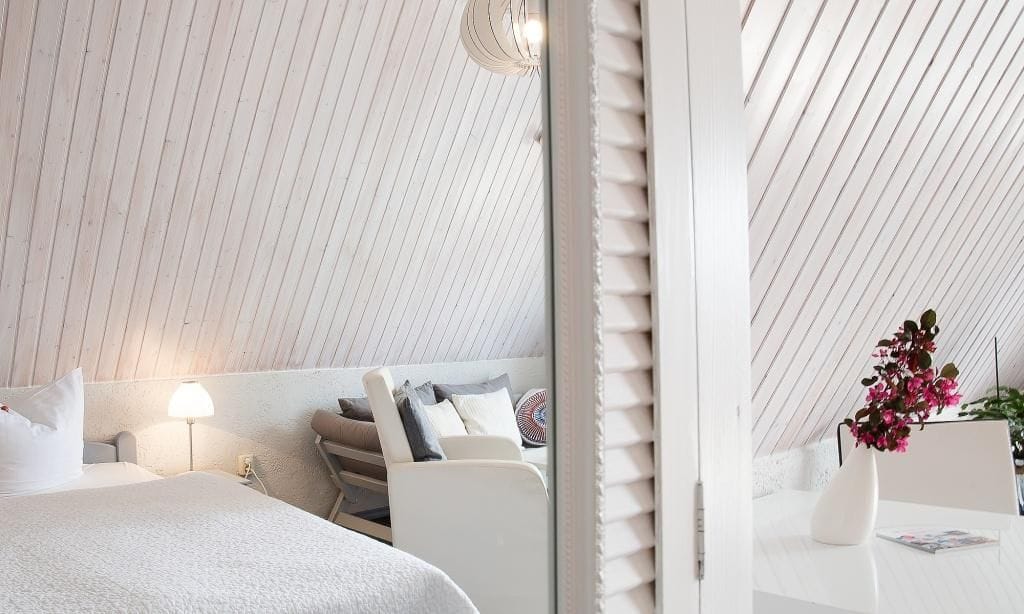 Schlafzimmer mit Holzdecken und gemütlicher Sitzecke