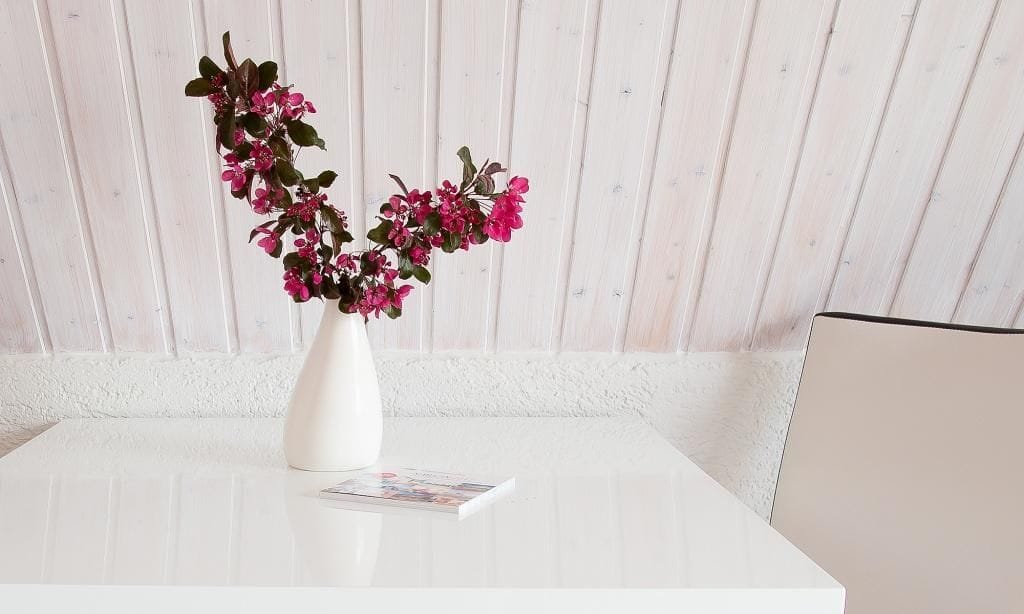 Minimalistischer Tisch mit Blumenarrangement