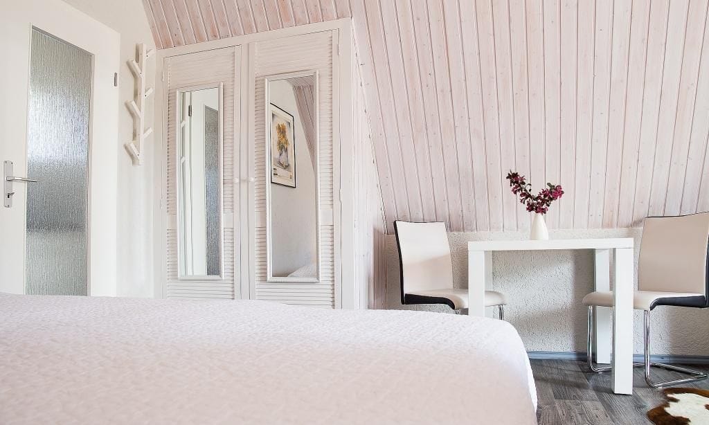 Schlafzimmer mit Bett, Tisch und Stühlen
