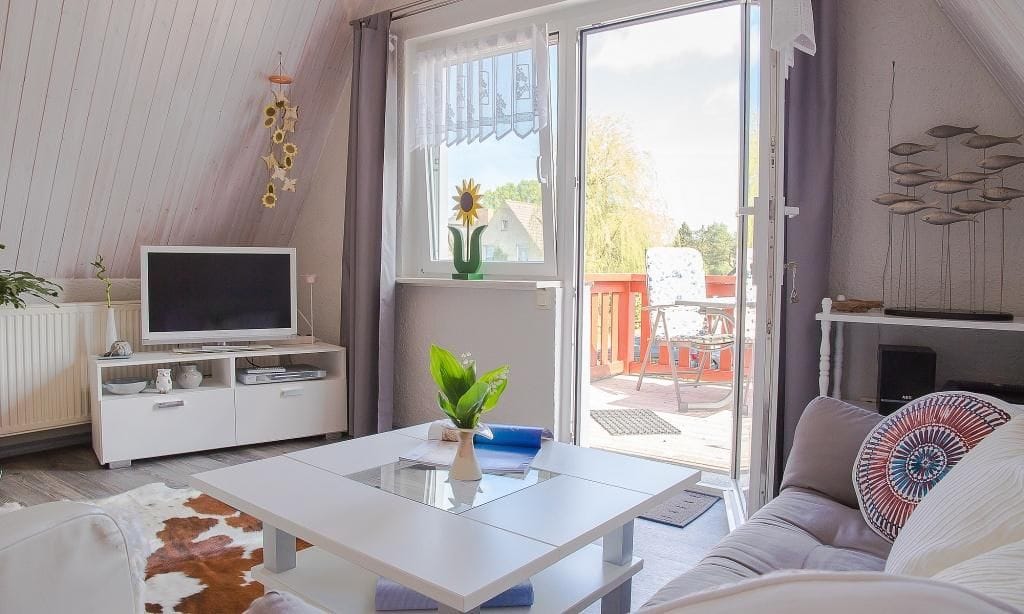 Gemütliches Wohnzimmer mit TV und Zugang zur Terrasse.