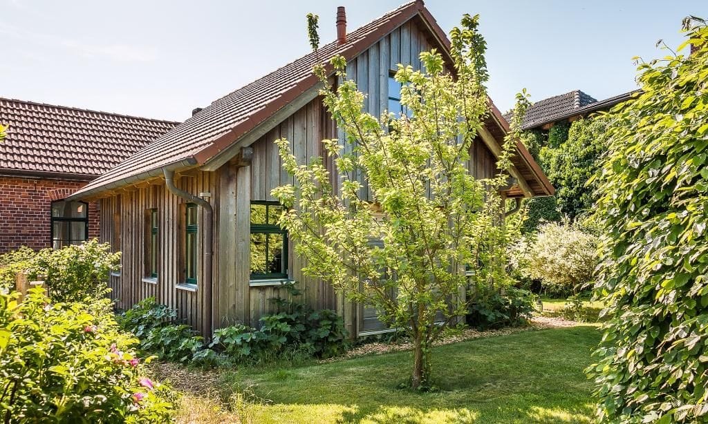 Außenansicht eines Holzhauses mit Garten