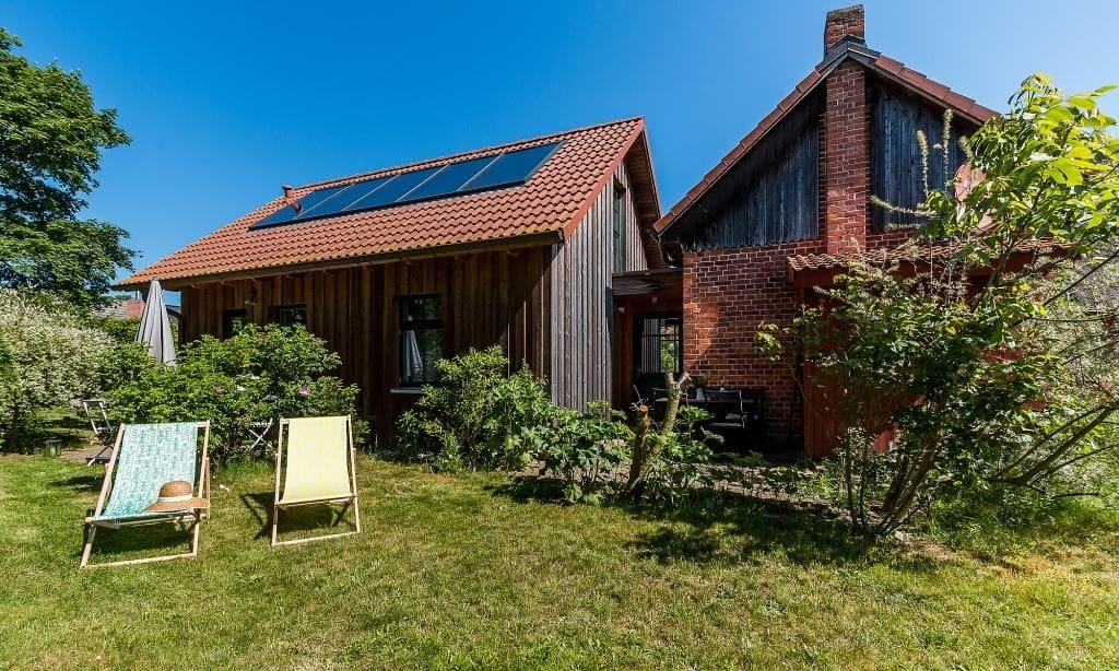 Außenansicht eines Hauses mit Garten und Liegestühlen
