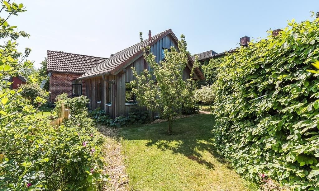 Außenansicht eines Holzhauses mit Garten