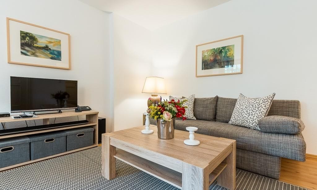 Helles Wohnzimmer mit Sofa und Fernseher