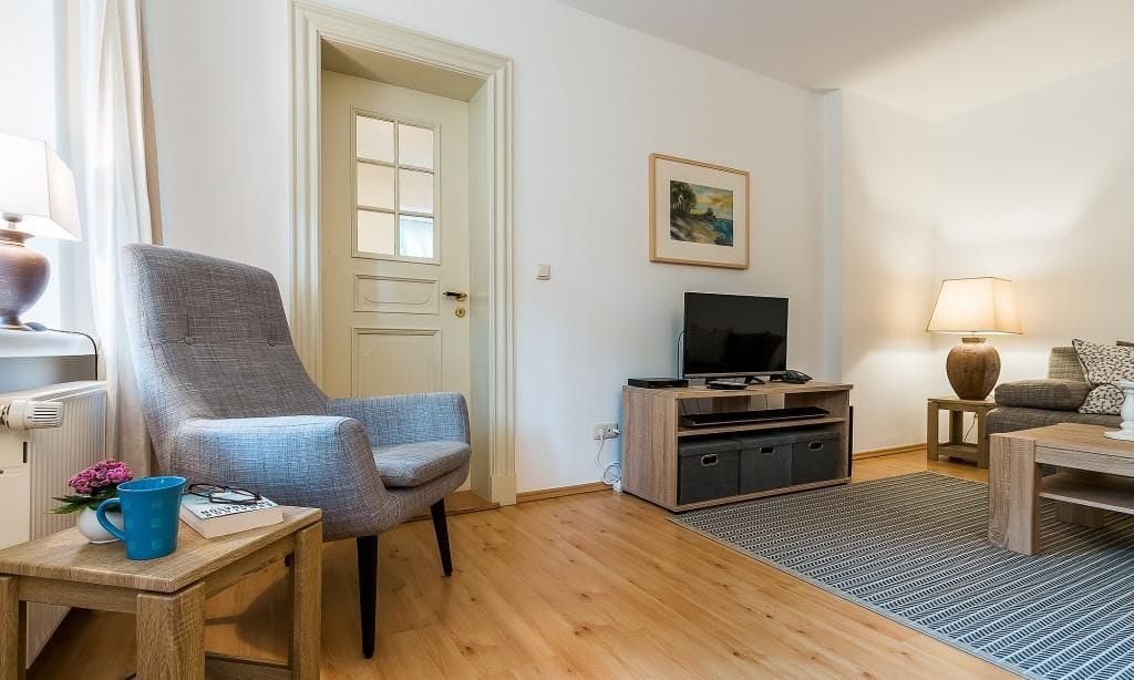 Heller Wohnraum mit Fernseher und Sessel