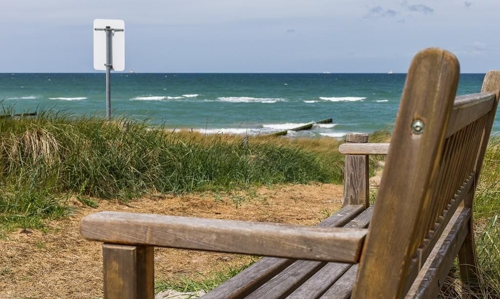 Strand mit Holzbank und Ausblick