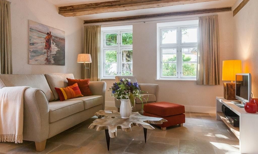 Gemütliches Wohnzimmer mit Sofa und großem Fenster