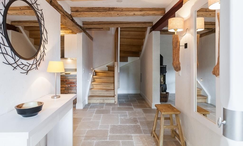 Heller Flur mit Holztreppe und Spiegel