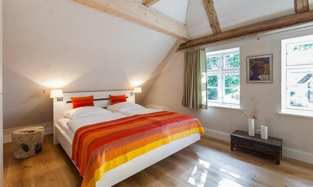 Schlafzimmer mit Doppelbett und Fenstern