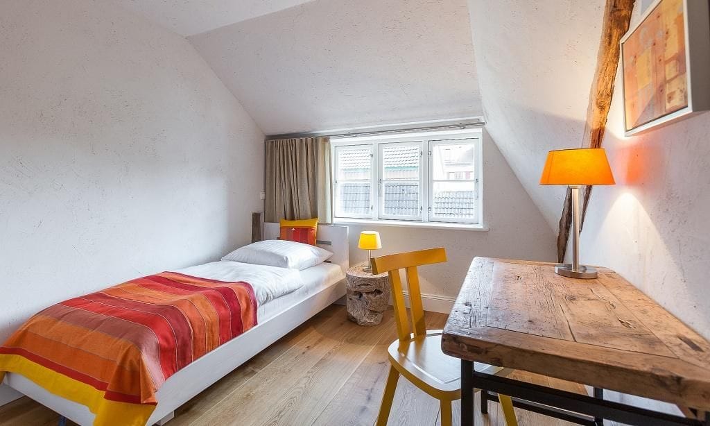 Schlafzimmer mit Einzelbett und Schreibtisch