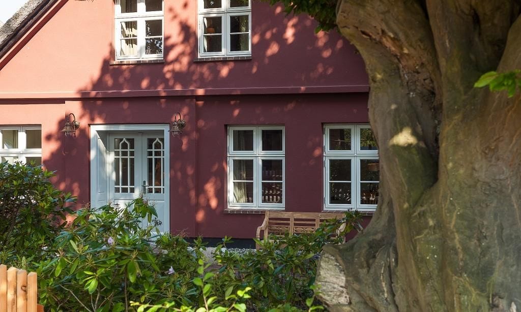 Außenansicht eines roten Hauses mit Fenstern