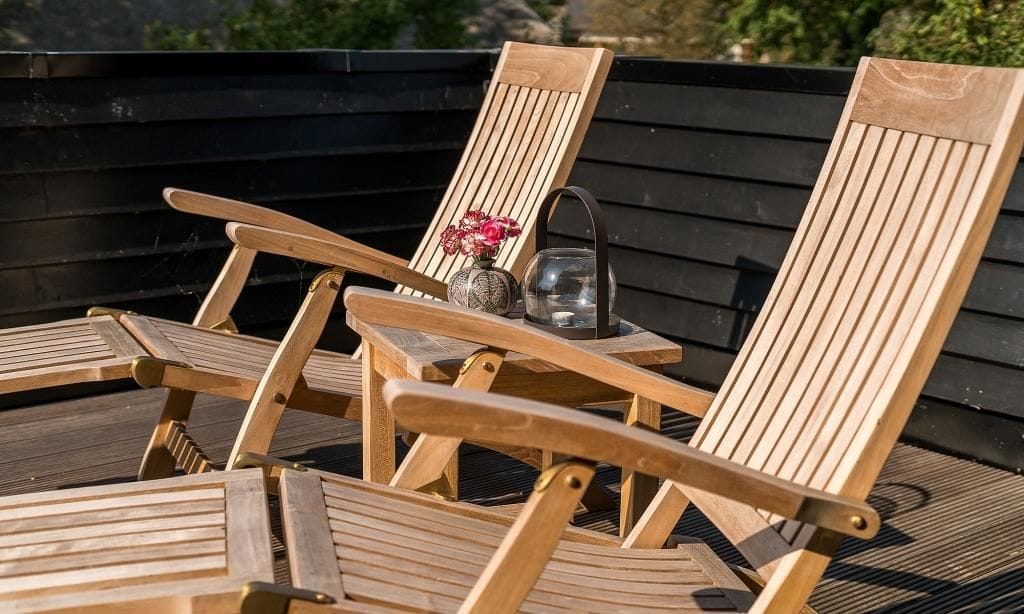 Terrasse mit Holzliegestühlen und Blumen