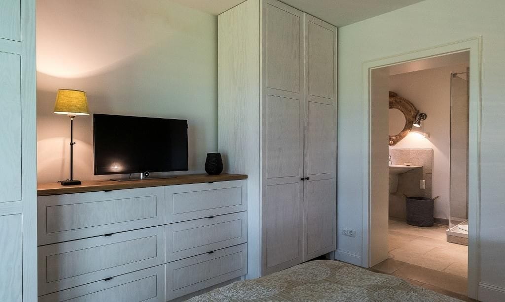 Schlafzimmer mit Fernseher und Kleiderschrank