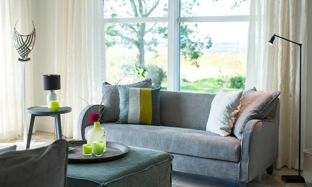 Helles Wohnzimmer mit Sofa und Blick ins Freie