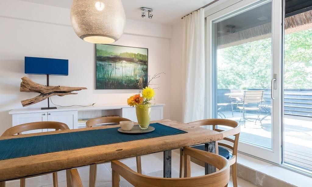 Moderne Küche mit Esstisch und Fenster zur Terrasse