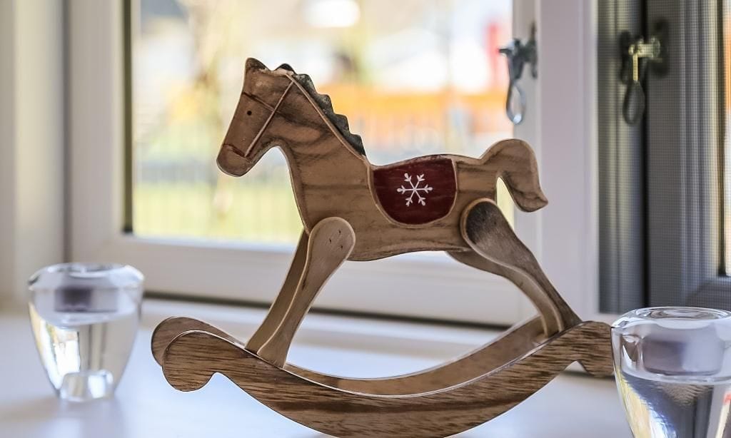 Holzspielzeug Pferd vor einem Fenster