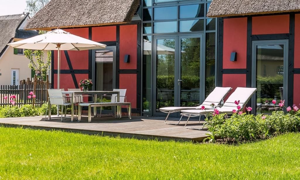 Terrasse mit Tisch und Liegen im Grünen