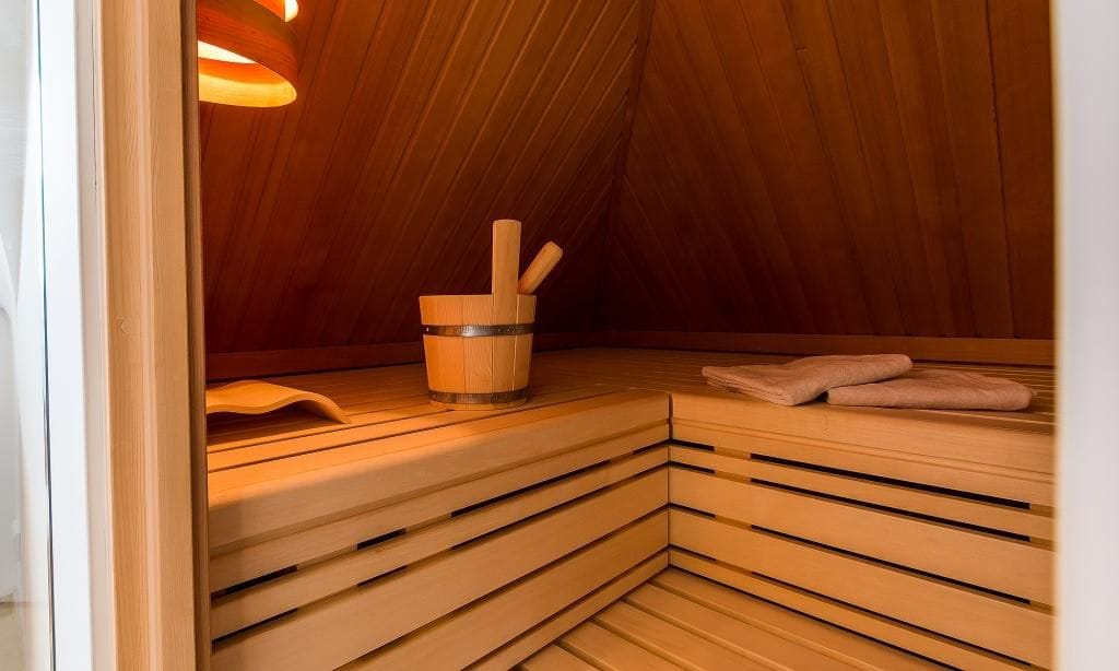 Gemütliche Sauna mit Holzbank und Aufgusszubehör
