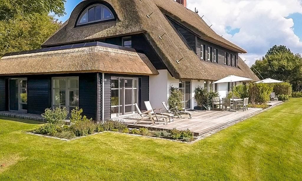 Außenansicht eines modernen Ferienhauses mit Reetdach