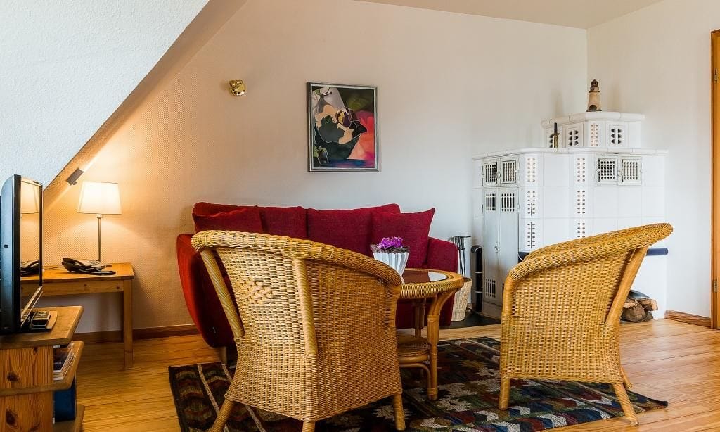 Gemütliches Wohnzimmer mit Sofa und Korbstühlen