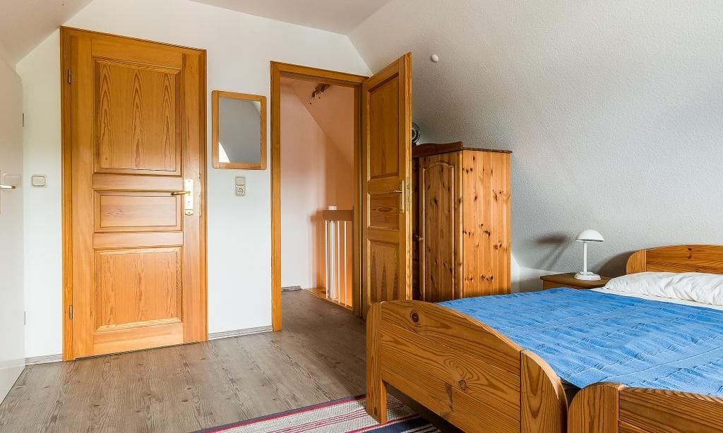 Schlafzimmer mit Holzkommode und Bett