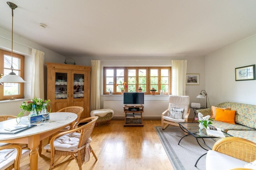 Gemütliches Wohnzimmer mit Esstisch und Fernseher.