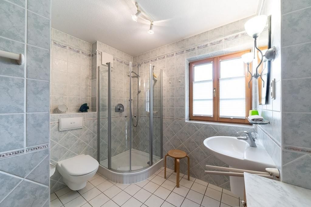 Helles Badezimmer mit Dusche und Waschbecken