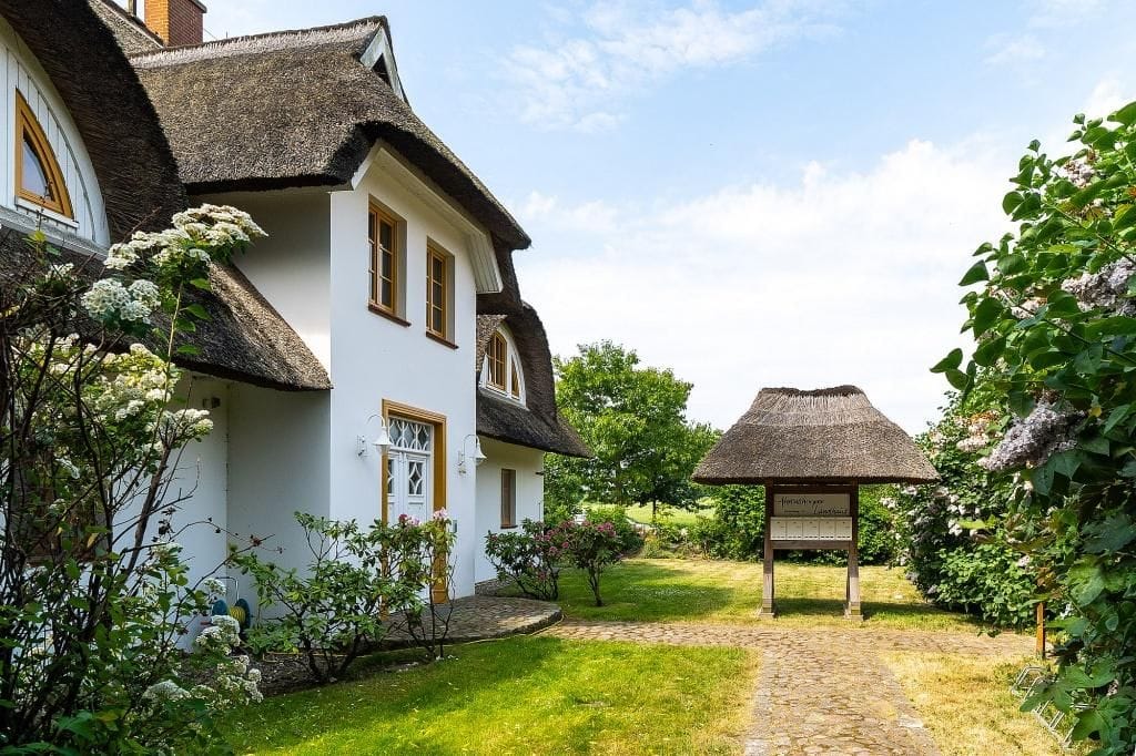 Außenansicht eines Reetdachhauses mit Garten
