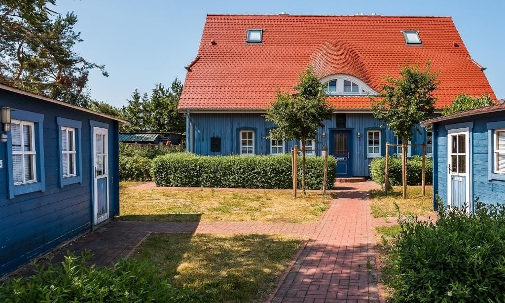 Außenansicht eines blauen Hauses mit rotem Dach