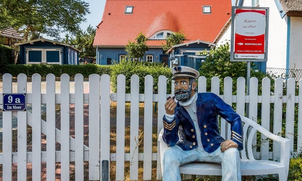 Außenansicht eines Ferienhauses mit Kapitänsfigur