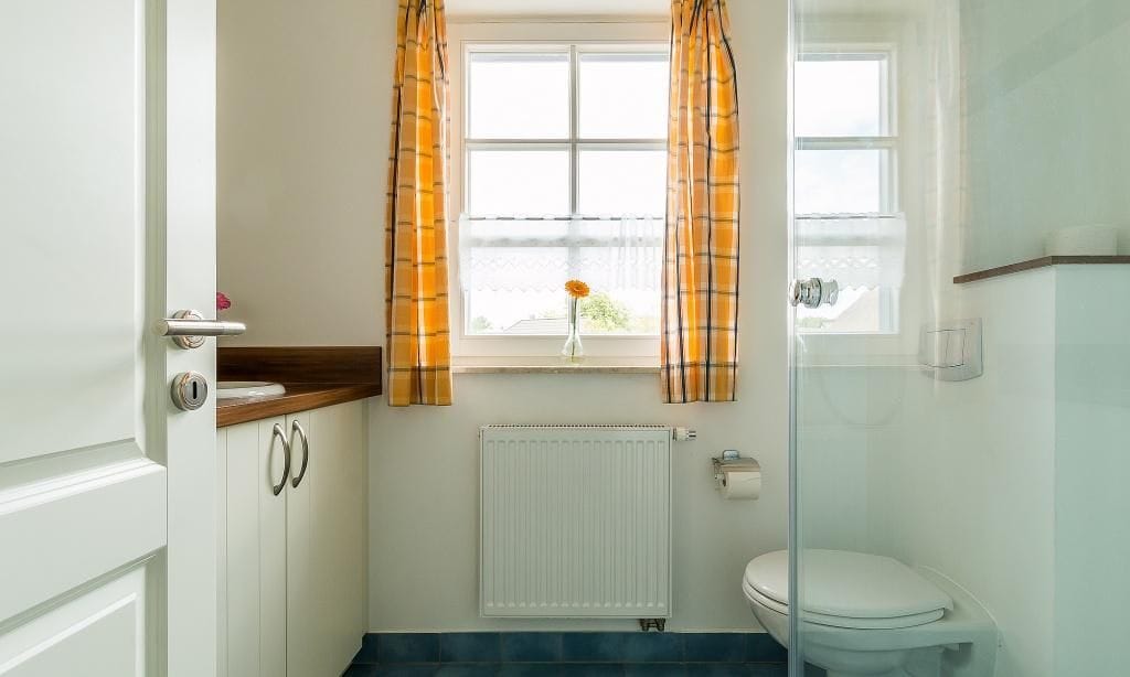Helles Badezimmer mit Dusche und Fenstern.