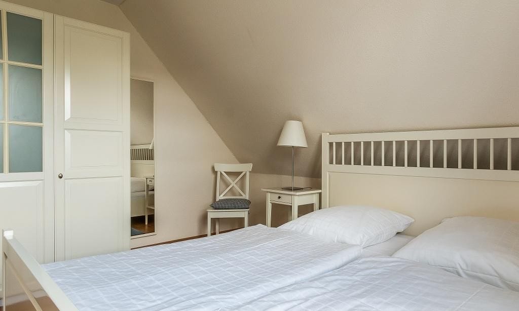 Helles Schlafzimmer mit Doppelbett und Nachttisch