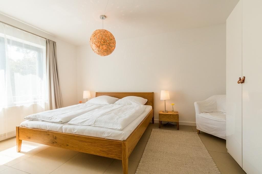 Helles Schlafzimmer mit Doppelbett und Stuhl