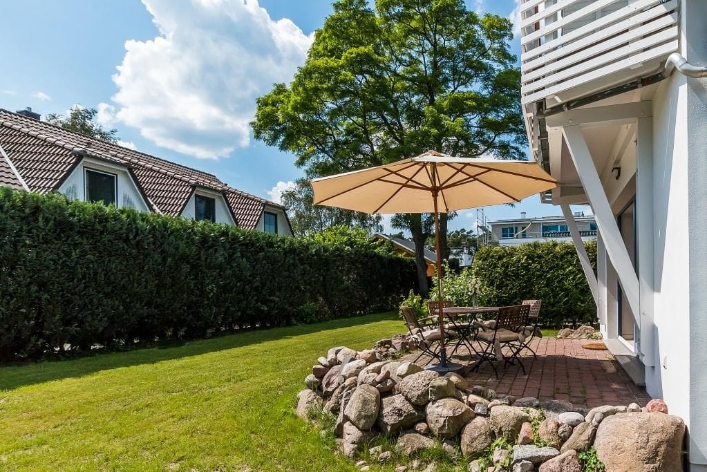 Terrasse mit Tisch und Sonnenschirm im Garten
