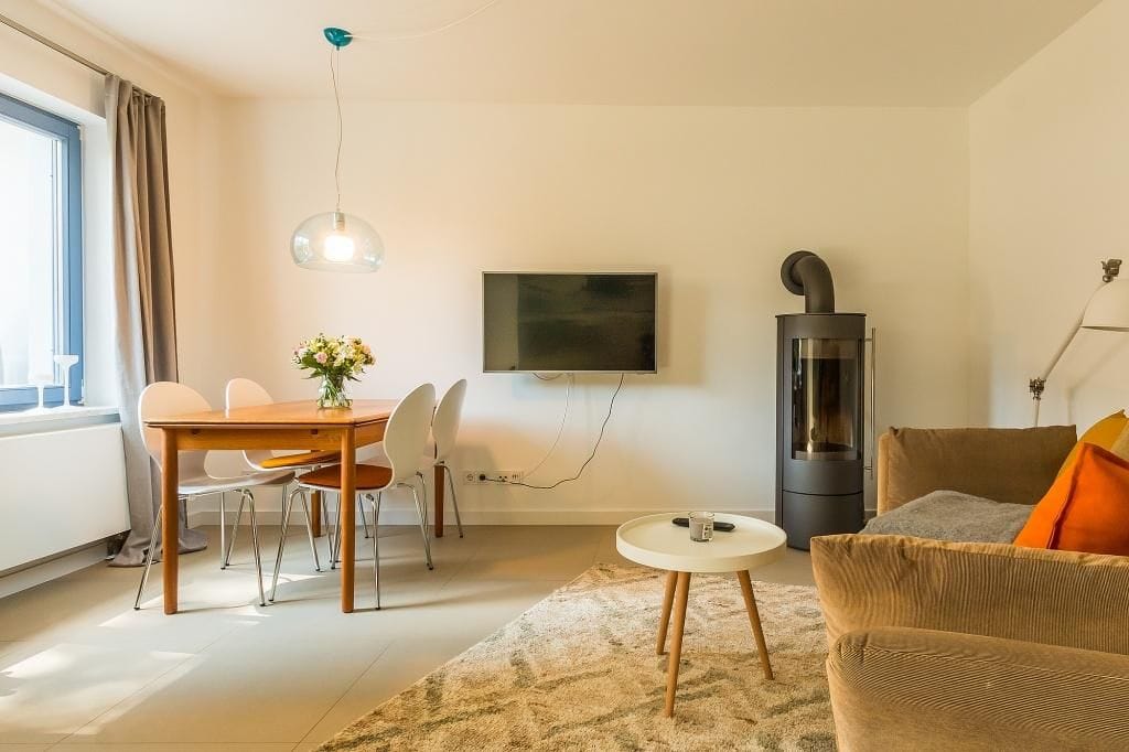 Helles Wohnzimmer mit Esstisch und Fernseher
