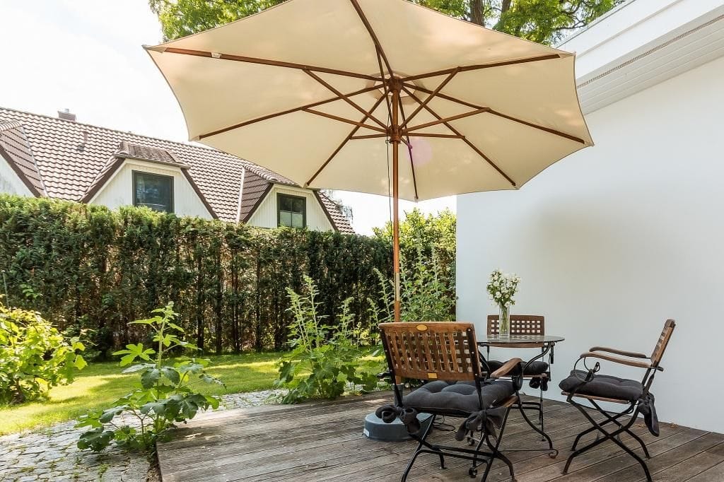 Terrasse mit Sonnenschirm und Gartenmöbeln