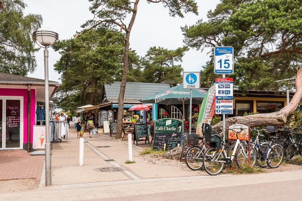 Belebte Strandstraße mit Geschäften und Fahrradparkplatz