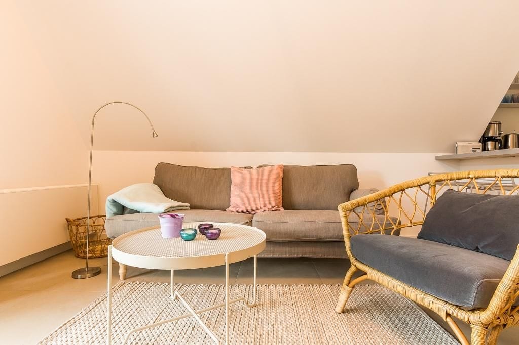 Gemütliches Wohnzimmer mit Sofa und Rattansessel