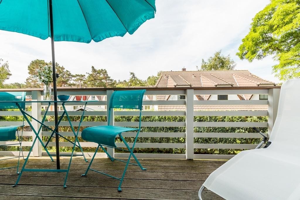 Moderne Terasse mit Stühlen und Sonnenschirm