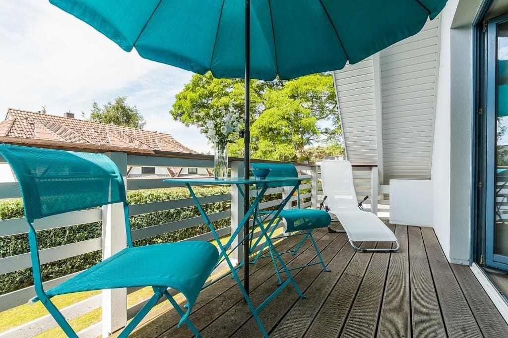 Terrasse mit blauen Stühlen und Sonnenschirm