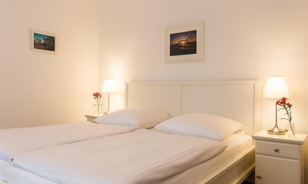 Helles Schlafzimmer mit Doppelbett und Nachttischen