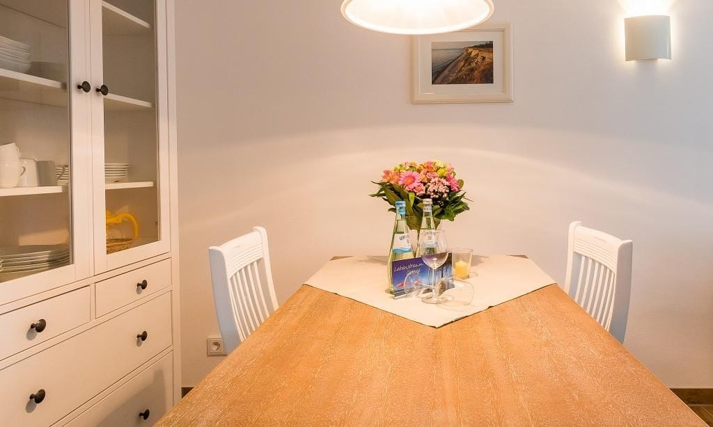 Essbereich mit Holztisch und weißen Stühlen