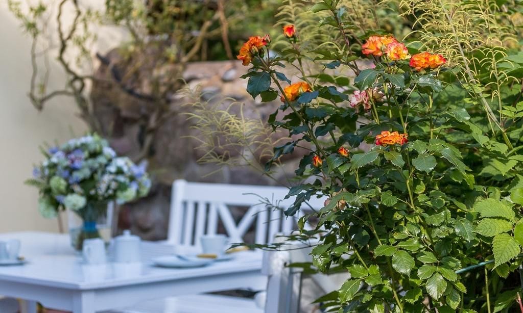 Terrasse mit Tisch und bunten Blumen
