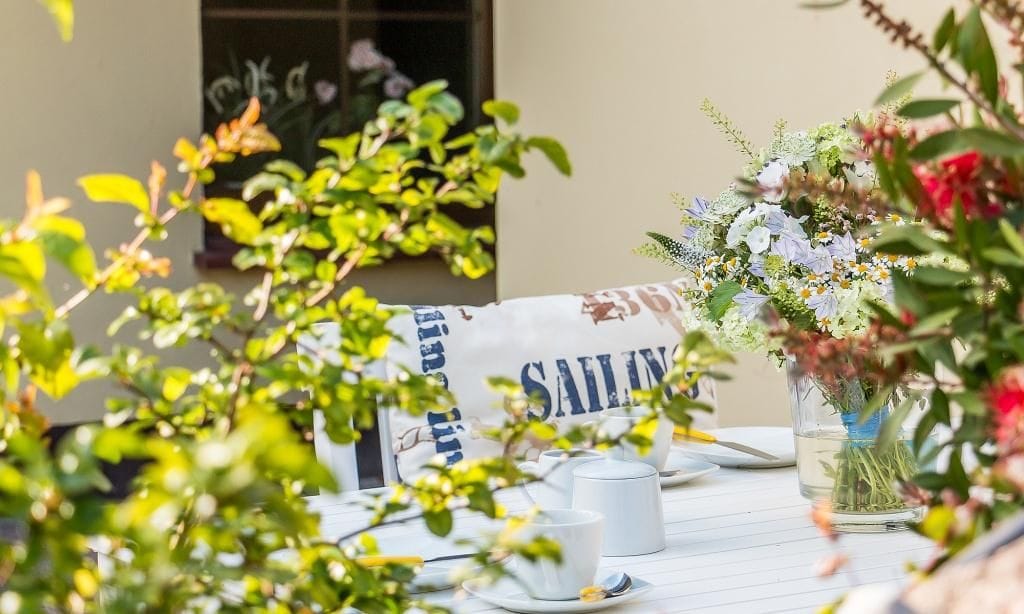 Terrasse mit Tisch und Blumenarrangement
