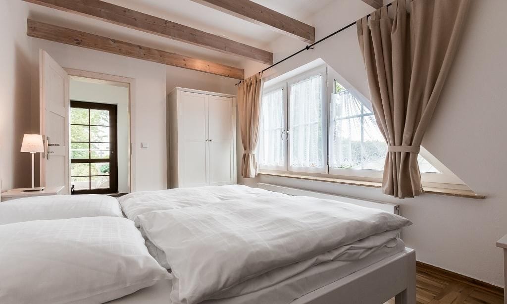 Helles Schlafzimmer mit Doppelbett und Holzdecken