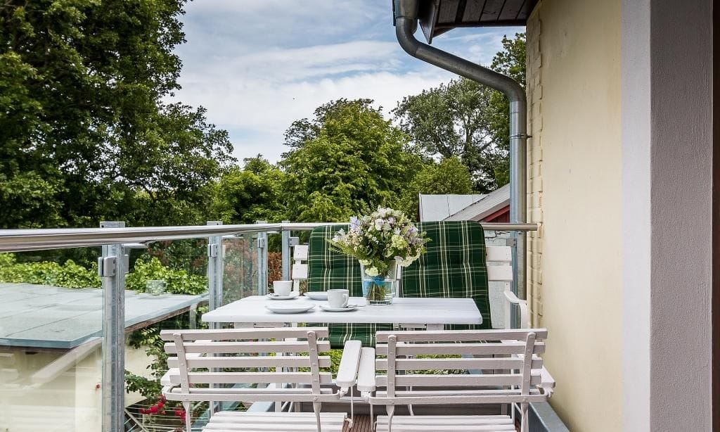 Terrasse mit Tisch und Stühlen umgeben von Bäumen