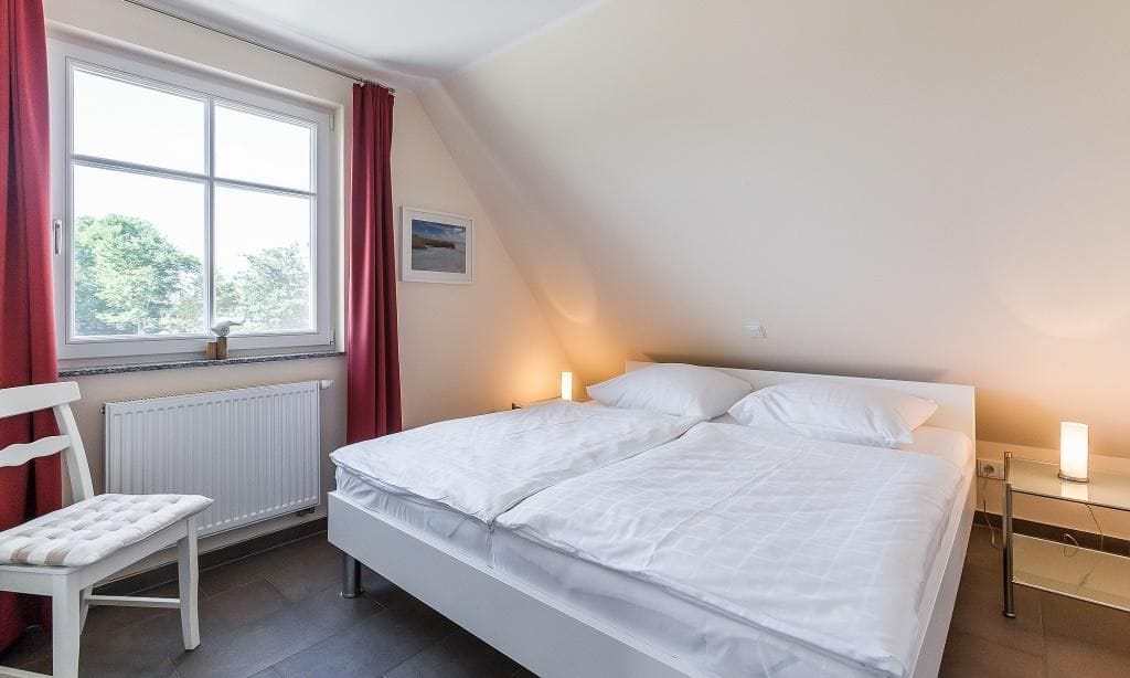 Schlafzimmer mit Doppelbett und Fenster