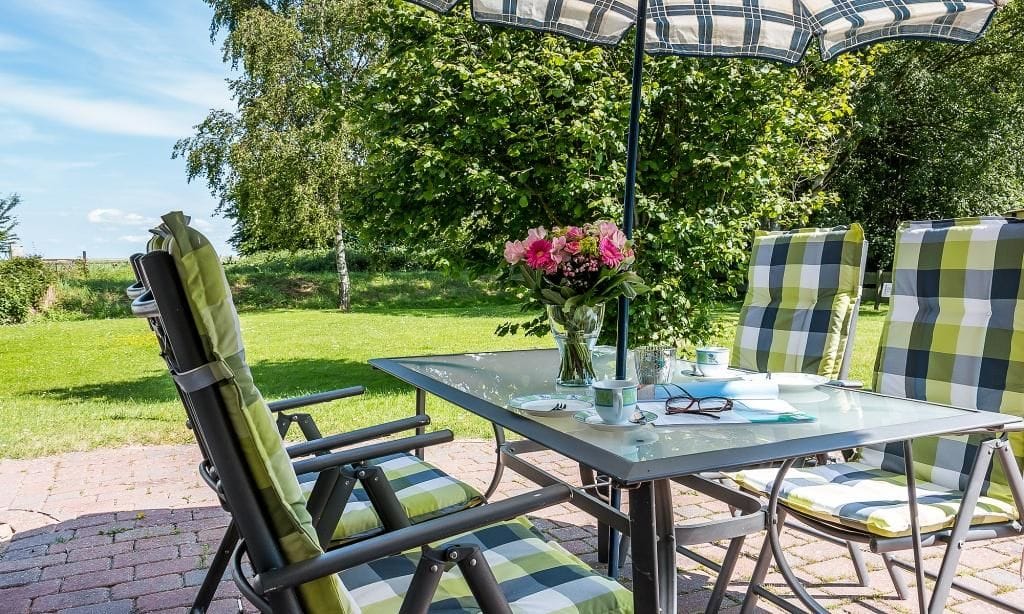 Terrasse mit Tisch und Sonnenschirm